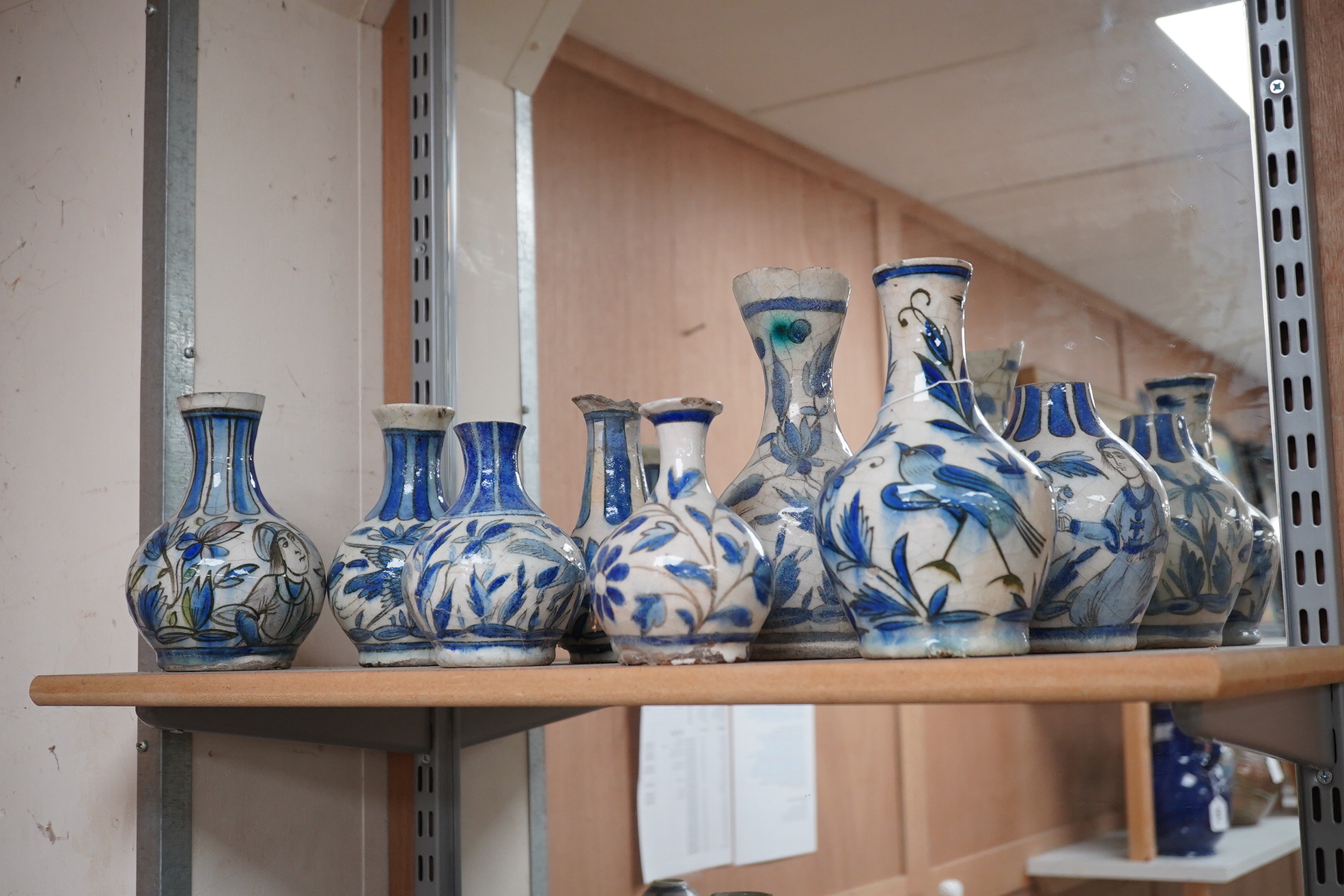 A large collection of Persian, predominantly blue and white, guglets, 18th century, largest 21.5cm. Condition - mostly damaged